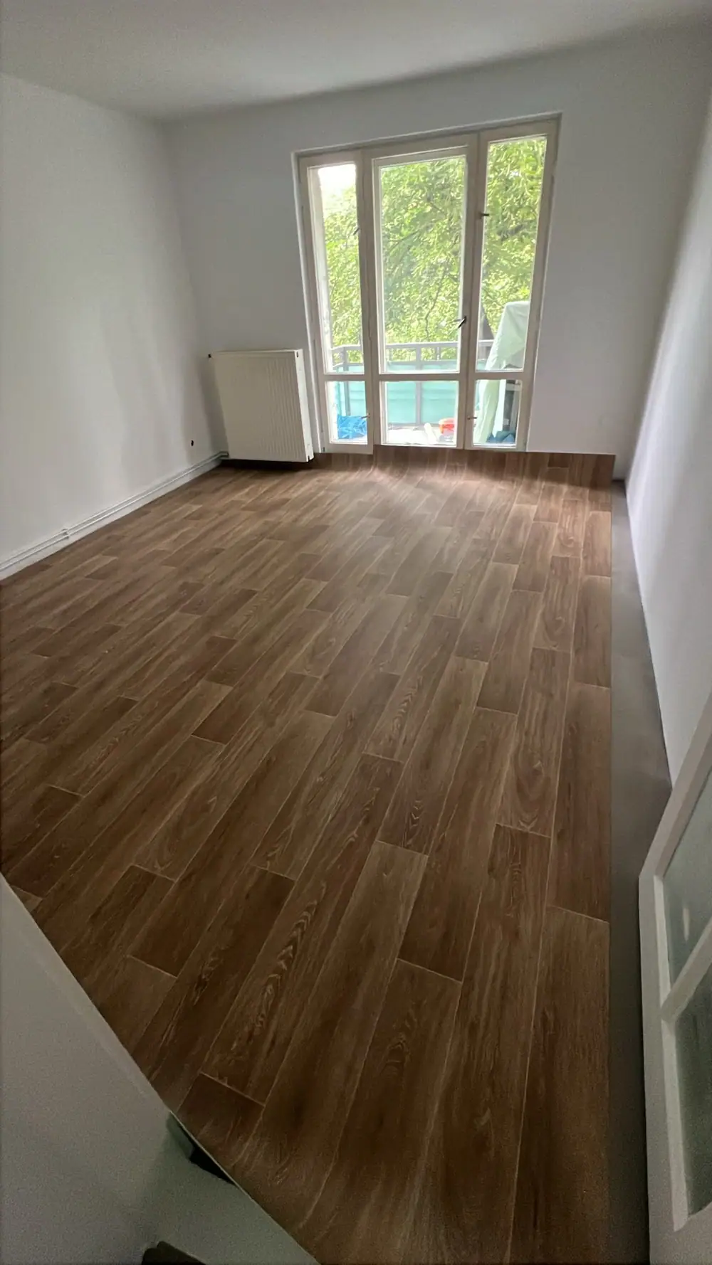 Zimmer mit neuem Vinylboden und Balkontür