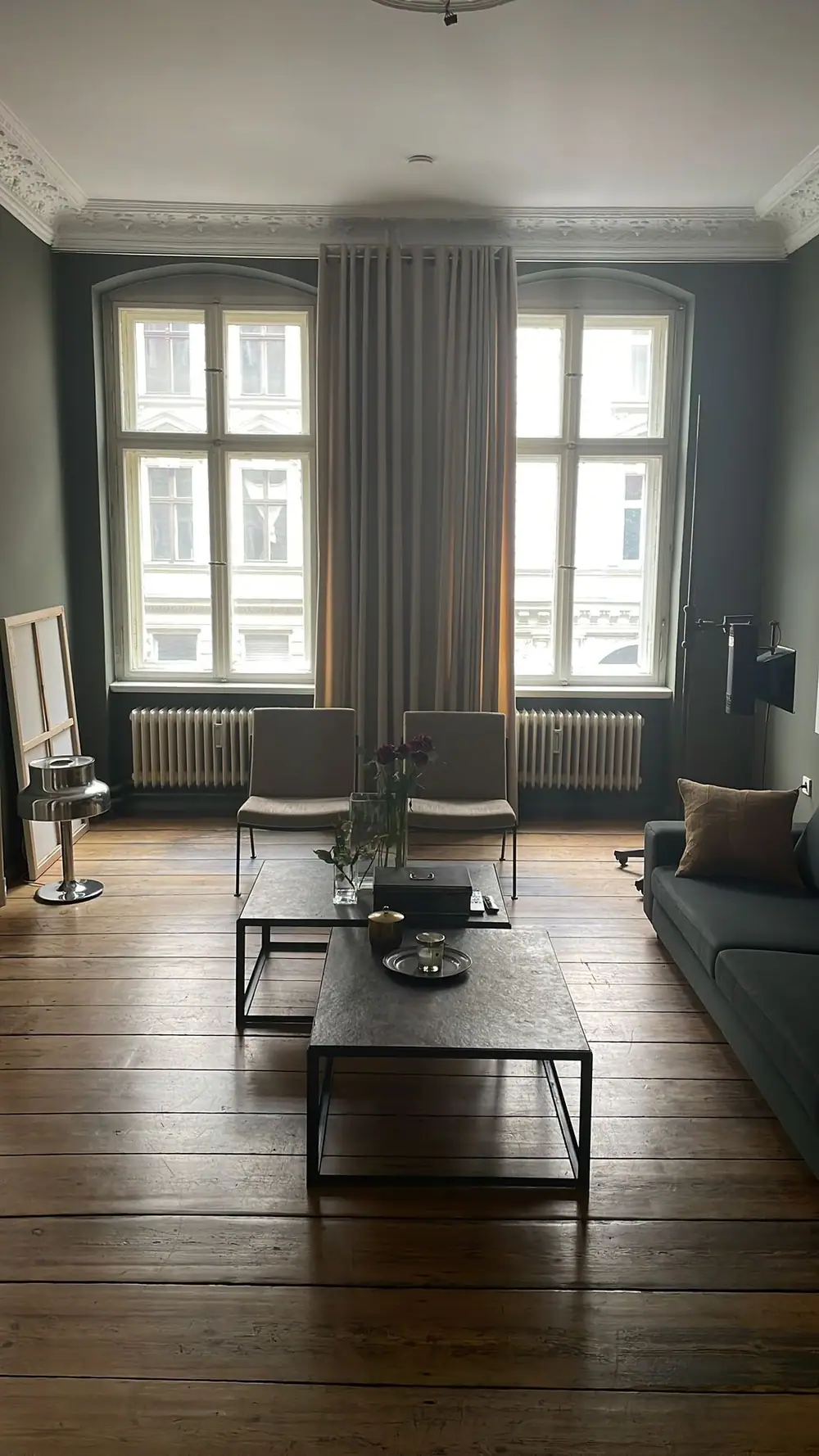 Altbausalon mit grünen Wänden, Stuckdecke und Dielenboden