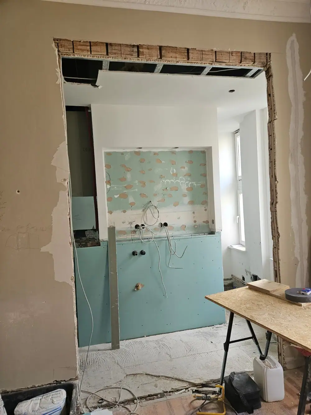 Wanddurchbruch mit grünen Feuchtraumplatten und Installationen