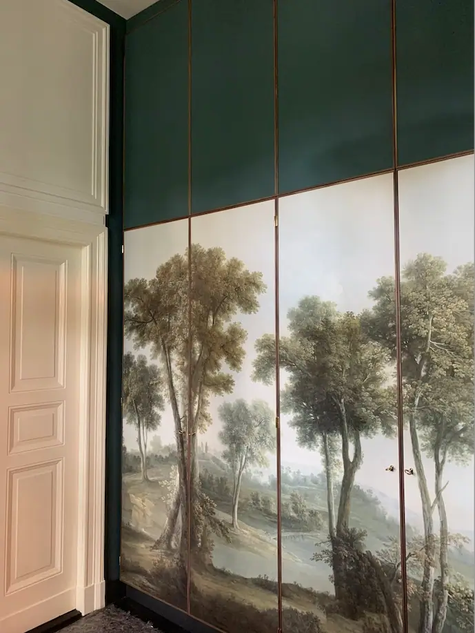 Zimmer mit handgezeichneter Panoramatapete und grünen Wandfeldern
