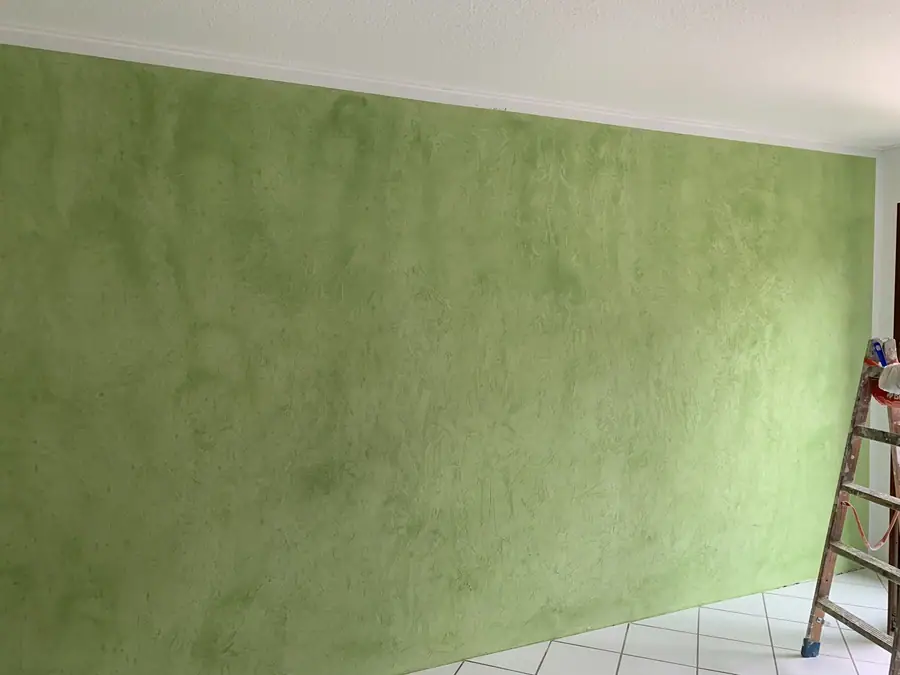 Große grüne Wand mit gespachtelter Struktur in einem Berliner Raum